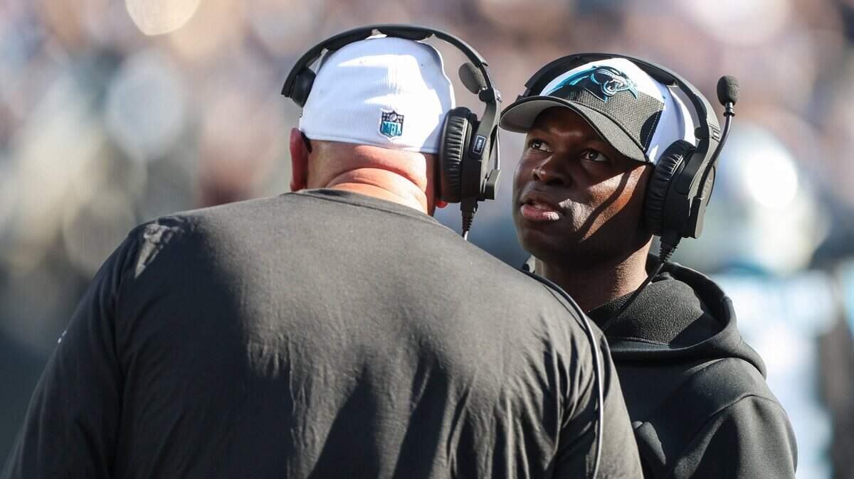 Panthers Defensive Coordinator Ejiro Evero talks with another coach on the sideline during the game against the Cowboys at Bank of America Stadium on Sunday, November 19, 2023 in Charlote, NC.