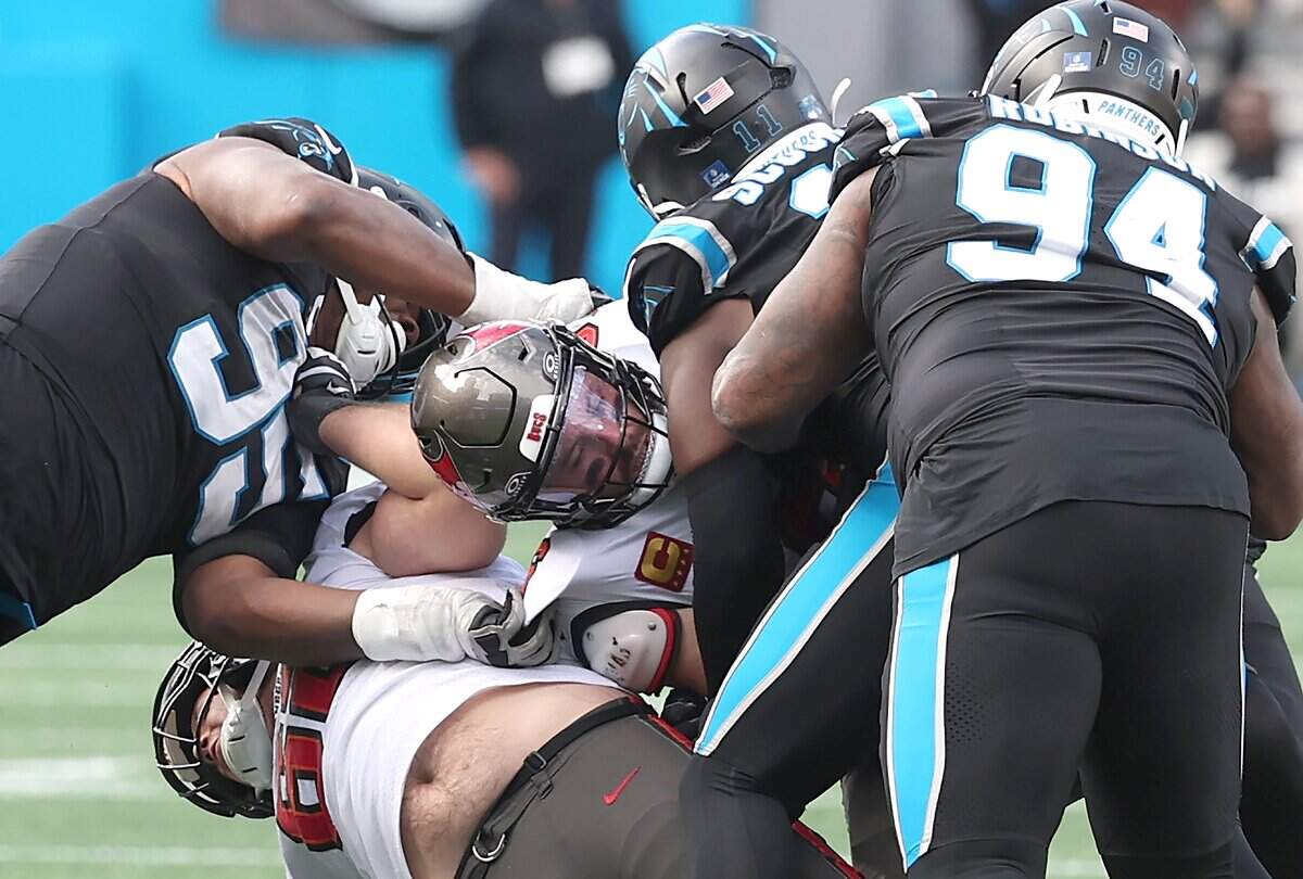 Members of the Carolina Panthers defense sack Tampa Bay Buccaneers quarterback Baker Mayfield, center, during action on Sunday, Dec. 21, 2025 at Bank of America Stadium in Charlotte. The Panthers defeated the Buccaneers 23-20.