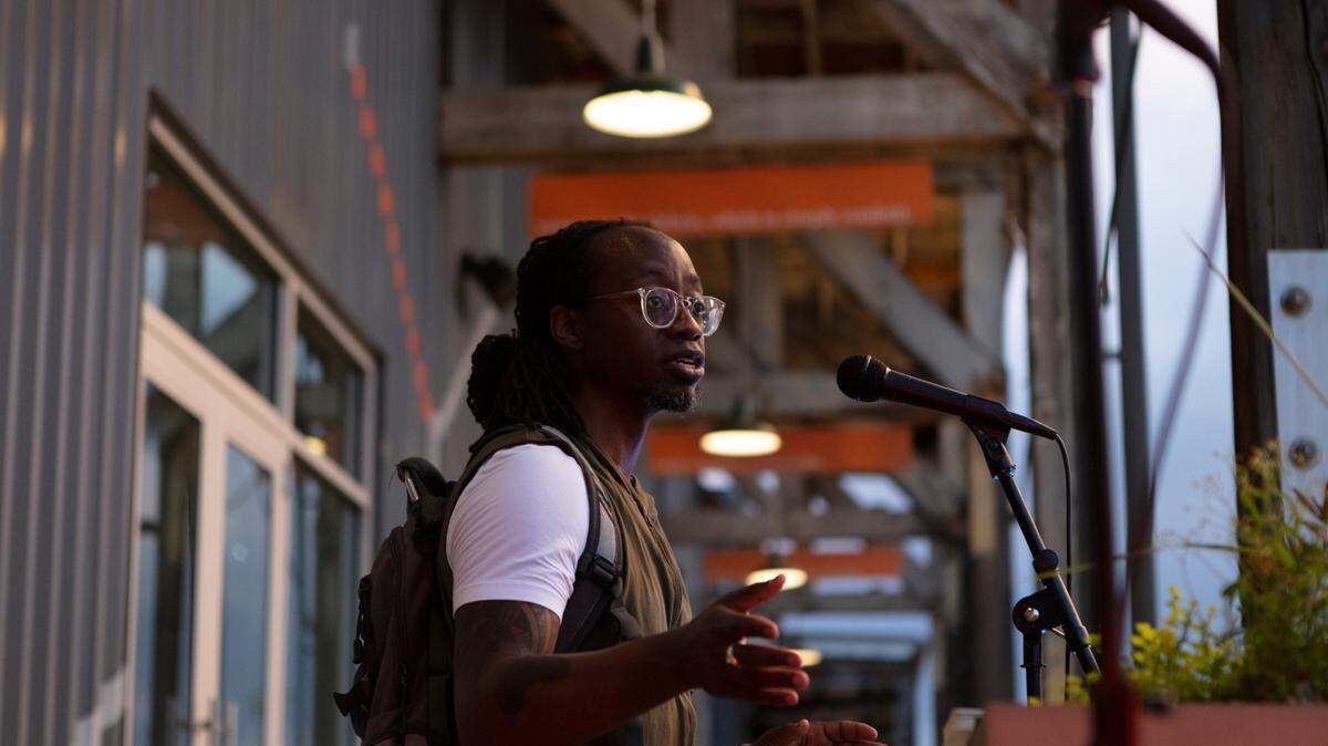Charlotte artist de’Angelo Dia performs at Joy Ride, a social distance/drive-through arts event that coincided with the George Floyd protests in Charlotte. Dia says his performance, titled “Pestilence: The Fatal Epidemic of Being Black in America,” was his poetic response to the tragic killings of Black people. Joy Ride took place at Camp Northend and participants listened through their car stereo systems.