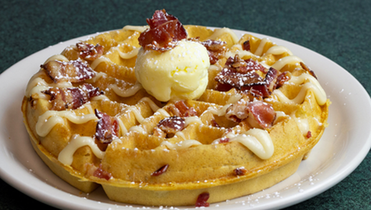 Metro Diner’s Fried Chicken & Waffles are topped with powdered sugar and strawberry butter and served with a signature sweet and spicy sauce.