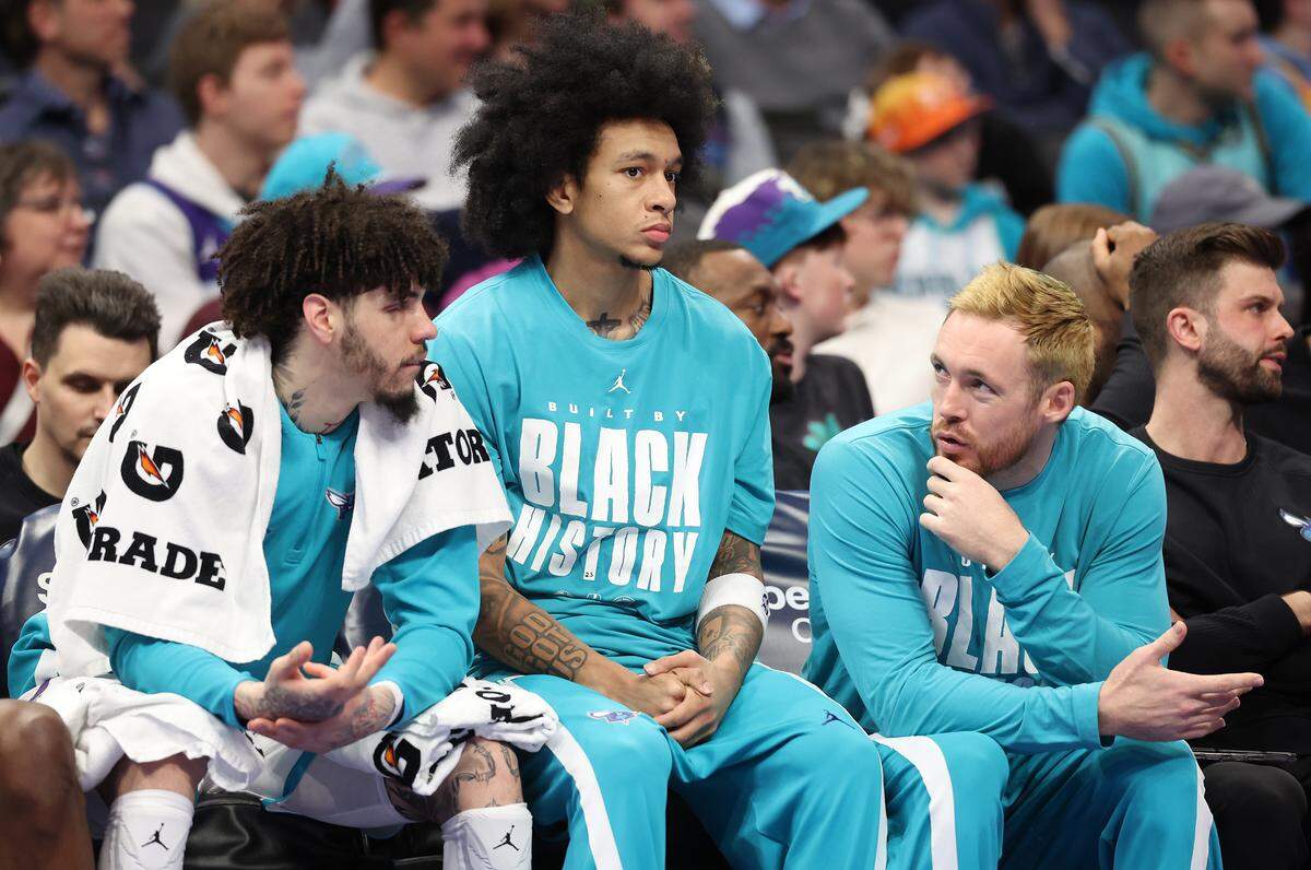 Charlotte Hornets guards LaMelo Ball, left Tre Mann, center and Pat Connaughton, right, sit on the bench during the team’s game against the New Orleans Pelicans at Spectrum Center in Charlotte, NC on Monday, February 2, 2026. The Hornets defeated the Pelicans 102-95.