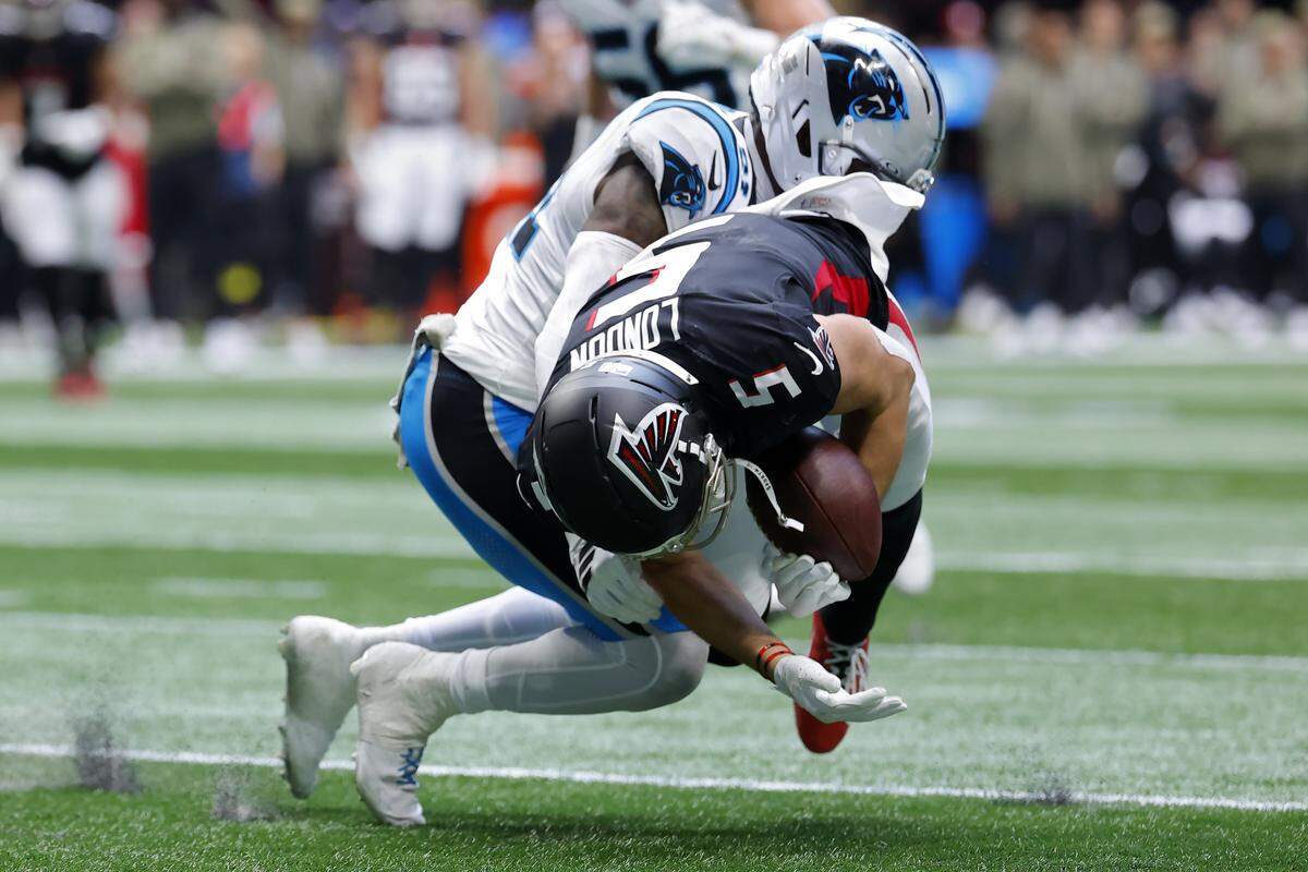 Drake London of the Atlanta Falcons is tackled by Nick Scott of the Carolina Panthers during Sunday’s second quarter at Mercedes-Benz Stadium in Atlanta.