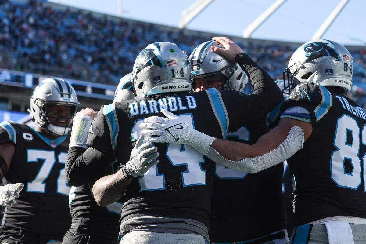 Panthers teammates celebrate after quarterback Sam Darnold scores a touchdown during the game against the Lions at Bank of America Stadium on Saturday, December 24, 2022.