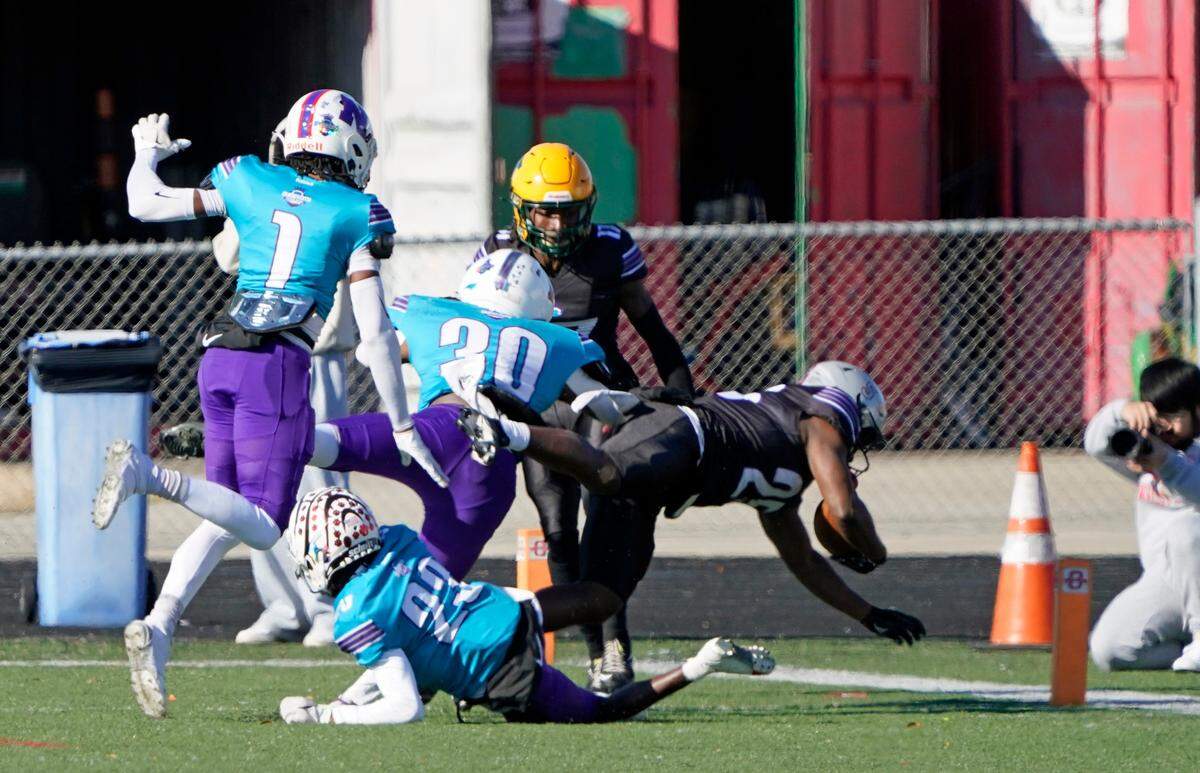 East running back Jayden Williiams of Butler High School, right, dives into the end zone on a 15-yard touchdown run during the second quarter of Saturday’s Queen City Senior Bowl high school football game at Olympic High School in Charlotte, N.C.. (CREDIT: Bill Kiser/Special to the Charlotte Observer)