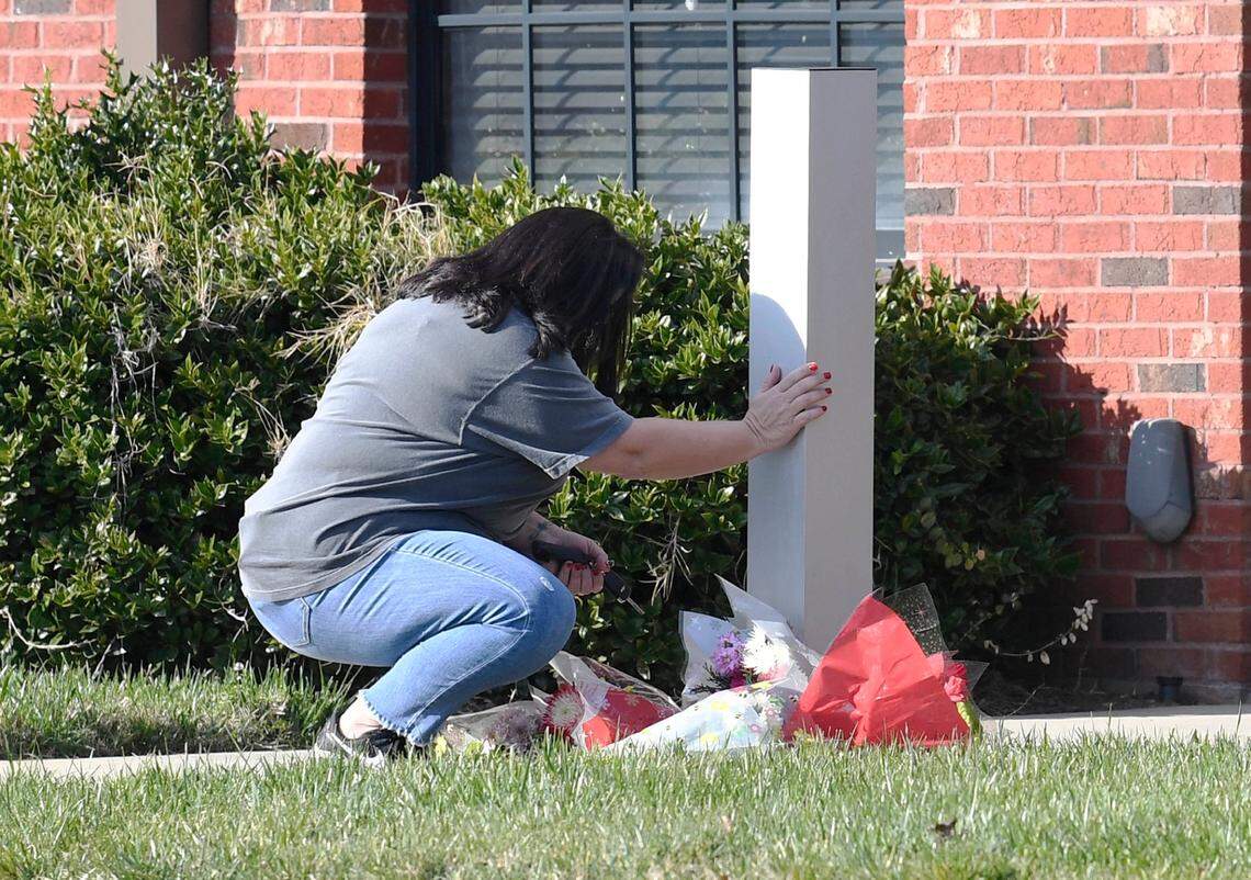 Angie Ewing of Mount Holly, NC prays after laying flowers outside the door of the Mount Holly Police Department on Friday, December 11, 2020 after an officer was shot and killed early Friday morning.
