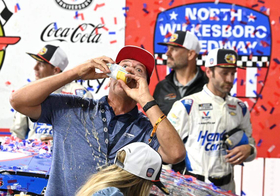 Former NASCAR driver Michael Waltrip shotguns a drink in victory lane as crew members for NASCAR driver Kyle Larson’s team celebrate winning the NASCAR All-Star race at North Wilkesboro Speedway on Sunday, May 21, 2023.