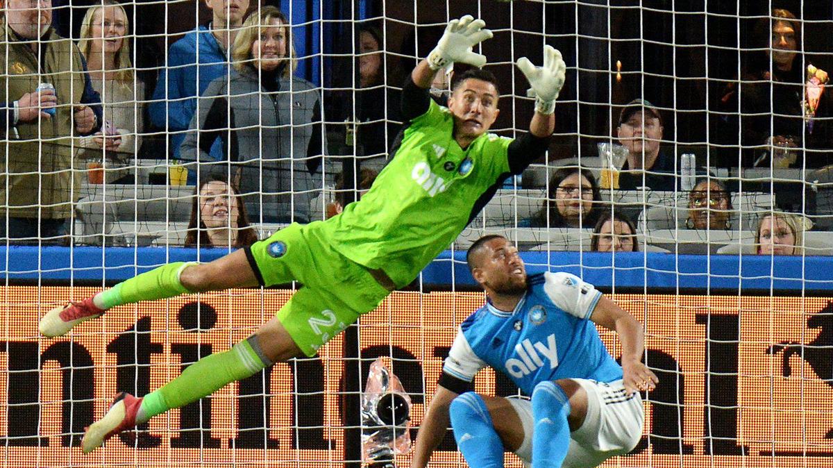Charlotte FC goalkeeper, #23, Pablo Sisniega made several diving saves including this one as he dove over teammate #6, Bill Tuiloma. Sisniega eventually surrendered a late second half goal in the 1-0 loss to the New England Revolution. Charlotte FC faced off against the New England Revolution in the season opener at Bank of America Stadium during a Saturday evening game on Feb. 25, 2023.