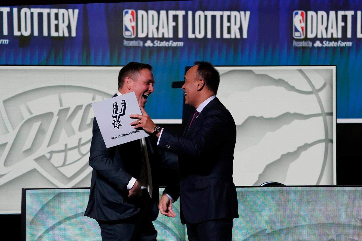 NBA Deputy Commissioner Mark Tatum (right) congratulates San Antonio Spurs managing partner Peter J. Holt (left) on the first pick in the 2023 NBA Draft Lottery at McCormick Place West.