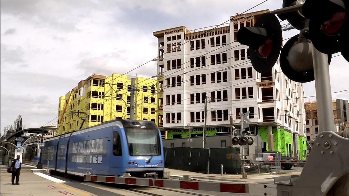 A light rail train passes through New Bern Street at Rail Crossing Lane, where high-end apartments keep springing up in South End. Despite city leaders saying affordable housing should be a priority near the light rail, almost none has been built.