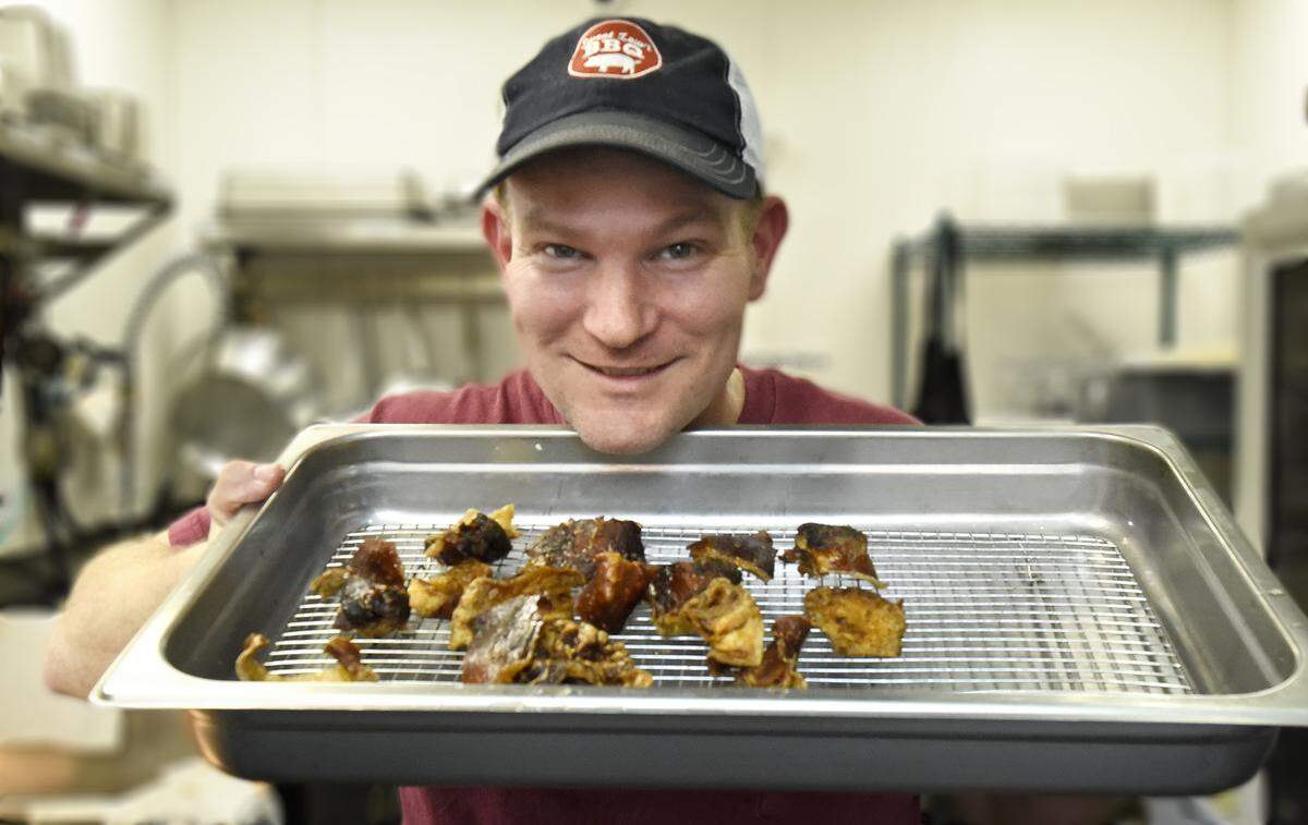 Lewis Donald of Sweet Lew’s turns the skin from his slow-cooked pork shoulders into fresh pork skins.