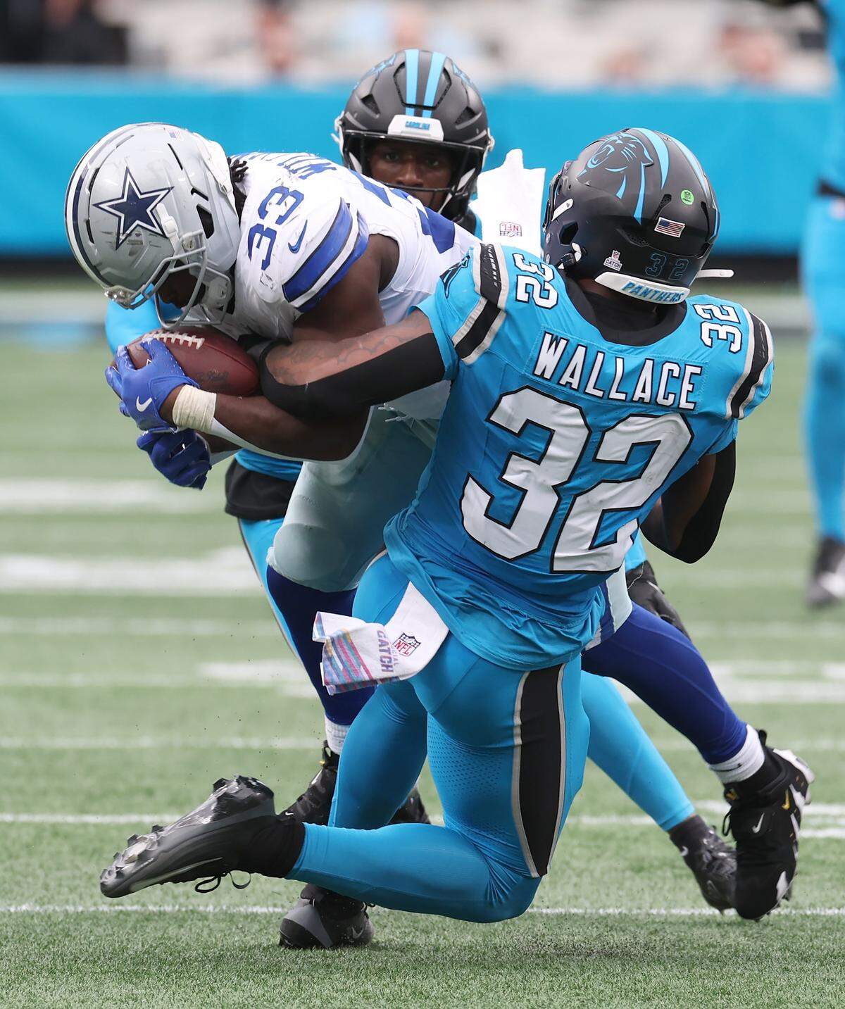Carolina Panthers linebacker Trevin Wallace, back to camera and cornerback Corey Thornton, facing camera, look to make the tackle on Dallas Cowboys running back Javonte Williams, center, during action on Sunday, October 12, 2025 at Bank of America Stadium. The Panthers defeated the Cowboys 30-27.