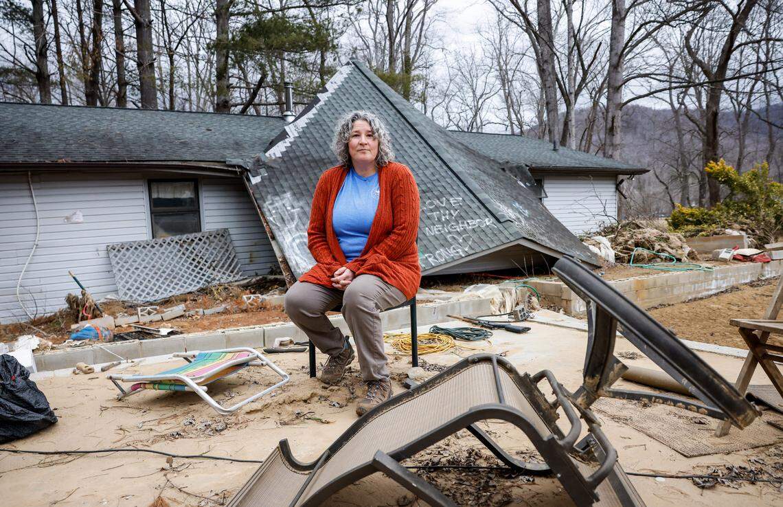 Sabrina Mills sits outside of her home after it was destroyed by flood waters, in Swannanoa, NC on Friday, January 31, 2025. Mills, her husband, two sons and a son’s friend were able to seek safety on the roof after her son carved a hole in the attic using a chef’s knife and a hammer. The house was pushed behind its foundation was saved from being pulled into the rushing river waters by a tree line in the backyard. Mills and her family were rescused hours later by volunteers.