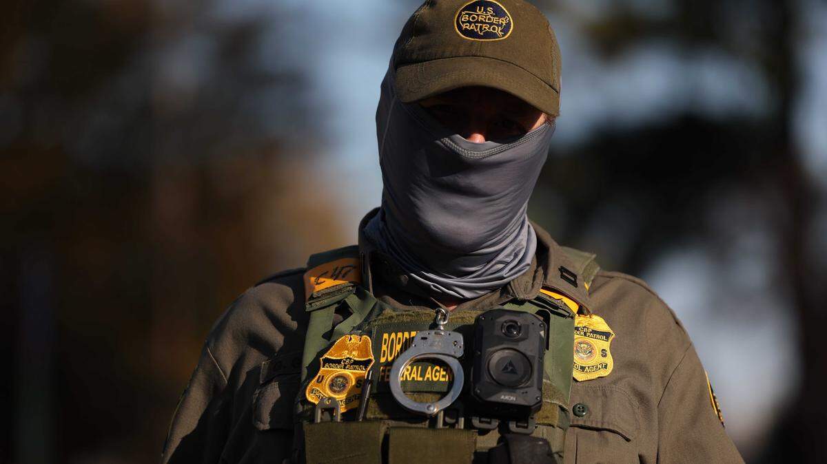 A Border Patrol Agent keeps watch while other agents make an arrest on Sharonbrook Drive in Charlotte on Sunday morning, Nov. 16.
