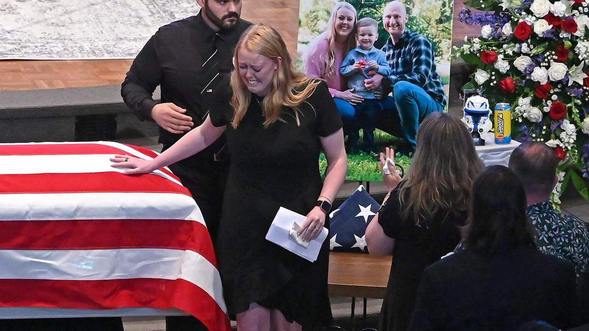 Ashley Eyer places her hand on husband Joshua Eyer’s casket after making remarks to mourners at First Baptist Church on Friday, May 3, 2024. Joshua Eyer was a Charlotte-Mecklenburg police officer, one of four law enforcement officers killed April 29, 2024 during a standoff in east Charlotte.