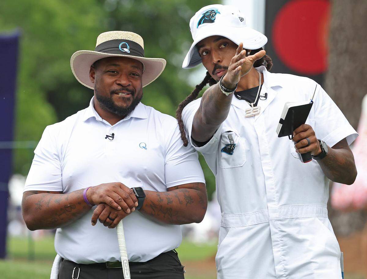 Former Carolina Panthers fullback Mike Tolbert, left, receives instructions from former safety Tre Boston, right, during the Truist Championship Pro-Am at Quail Hollow Club in Charlotte, NC on Wednesday, May 6, 2026.