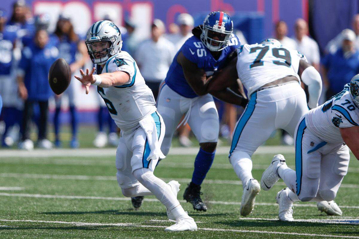 Carolina Panthers quarterback Baker Mayfield, left, pitches the ball during the first half Sunday. Mayfield generally handled the ball better Sunday, but he threw for only 145 yards.