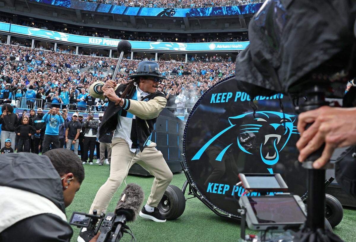 Former Carolina Panthers quarterback Cam Newton hits the Keep Pounding drum prior to the team’s game against the Los Angeles Rams at Bank of America Stadium on Saturday, January 10, 2026. The Rams defeated the Panthers 34-31.