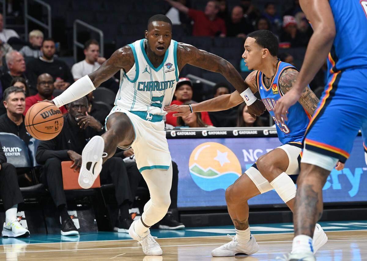 Charlotte Hornets guard Terry Rozier, left, lifts his right leg in the air as he prepares to drive to the basket against Oklahoma City Thunder guard Tre Mann, right, during first half action on Sunday, October 15, 2023 at Spectrum Center in Charlotte, NC.