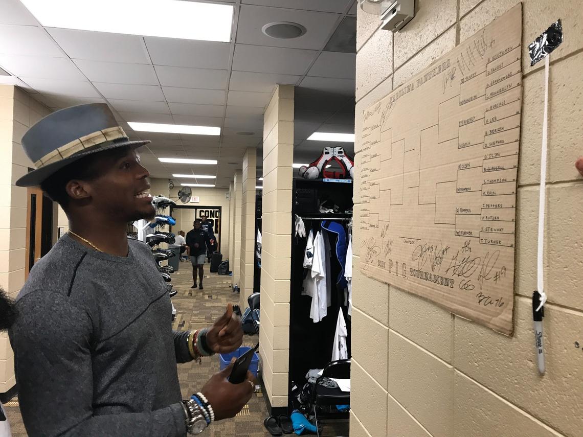 Panthers quarterback Cam Newton glances at a PIG bracket posted in the Carolina locker room. Newton was an avid participant in the game each year. Laughs PIG commissioner Ryan Kalil, the Panthers center who ran the game and handled all disputes: “The rulebook evolved over time. And by the way, Cam is a big part of us having to have a lot of amendments to the rules, just because he would always try to find some loophole or some edge.”