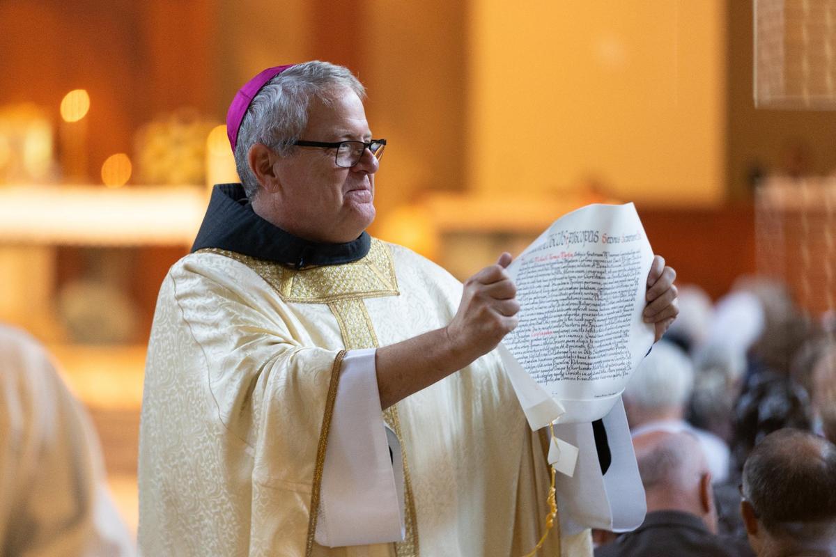 Bishop-elect Michael T. Martin holds the Apolstolic Letter from Pope Francis appointing him as the Bishop of Charlotte his ordination at Saint Mark Catholic Church in Huntersville on May 29, 2024.