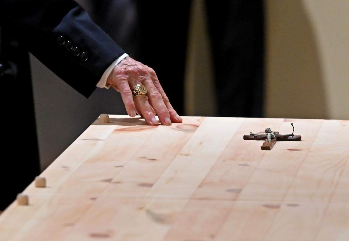 A mourner touches the casket of former Charlotte Motor Speedway president H.A. “Humpy” Wheeler at St. Gabriel Catholic Church in Charlotte on Tuesday, August 26, 2025.