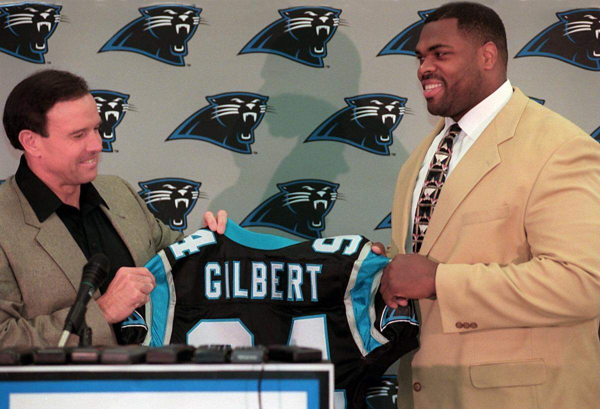 In April 1998, Panthers head coach Dom Capers and new Carolina defensive tackle Sean Gilbert admire Gilbert’s new jersey. The exorbitant price the Panthers paid to acquire Gilbert would later be derided as one of the worst personnel moves in team history.