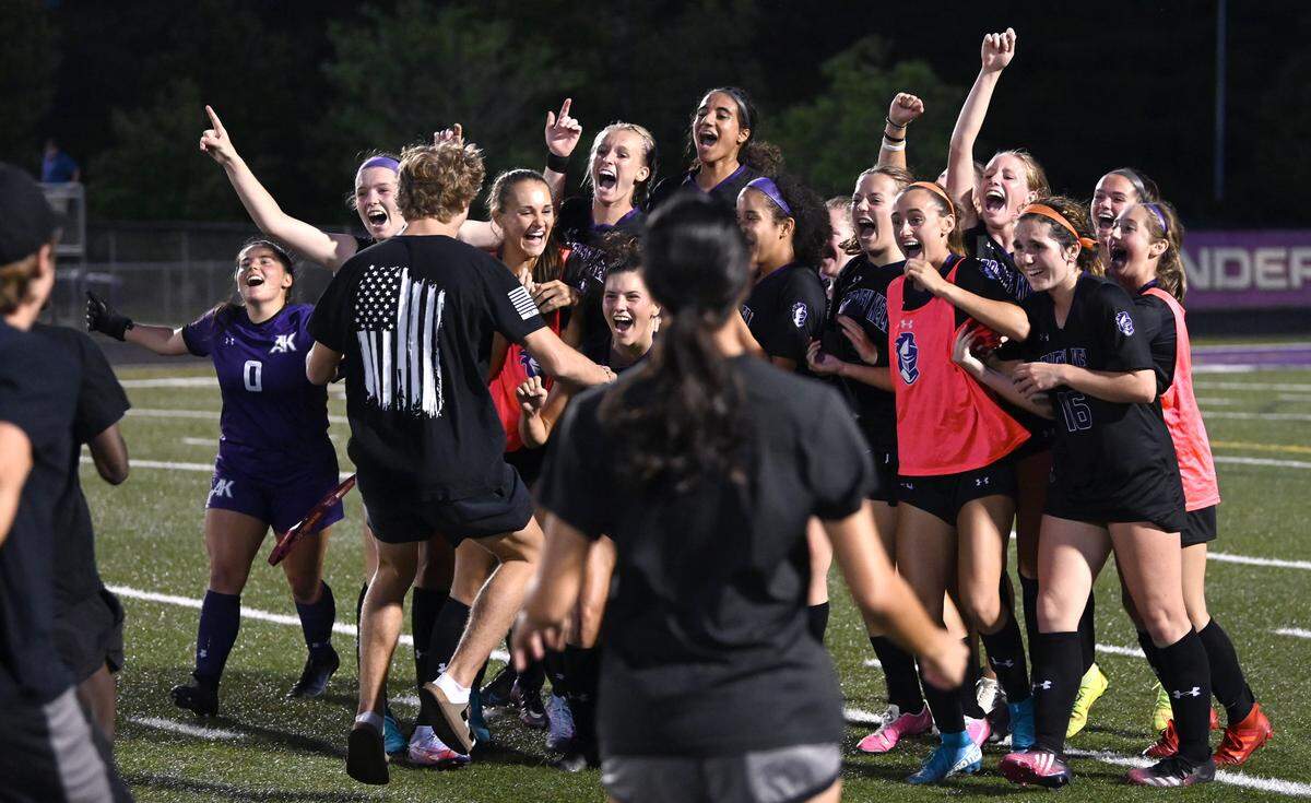 The Ardrey Kell girls soccer team turn to celebrate their 2-1 victory over Hough with their fans as they rush onto the field on Thursday, May 26, 2022. The teams were competing in a state quarterfinals girls soccer match.
