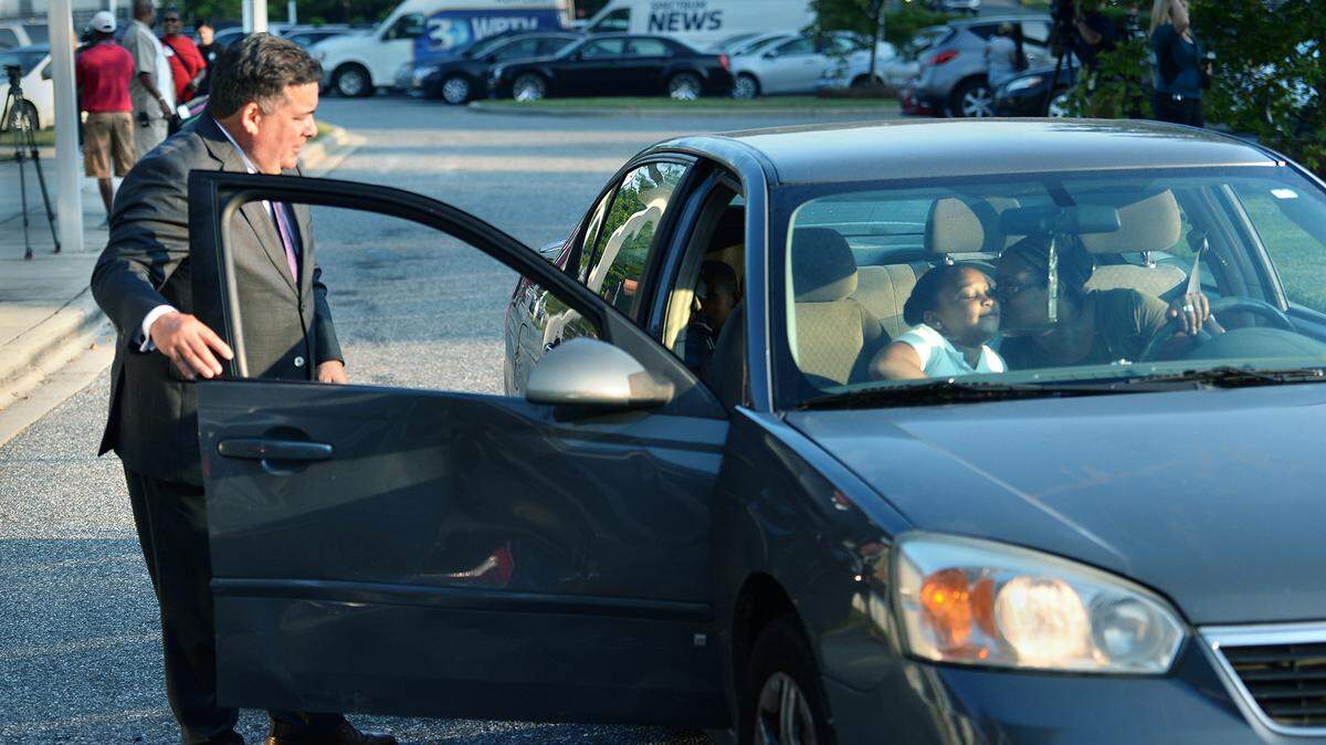 Eight-year-old Tyshayla Wilson gets a first-day-of-school goodbye kiss from her mother, LaQuawana Wilson, as Charlotte-Mecklenburg Superintendent Clayton Wilcox greeted families at Tuckaseegee Elementary’s drop off line on Monday.