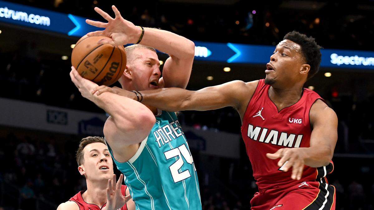 Charlotte Hornets center Mason Plumlee, center, fights to maintain control of the ball as Miami Heat guard Kyle Lowry, right, reaches in during first quarter action on Thursday, February 17, 2022 at Spectrum Center in Charlotte, NC.