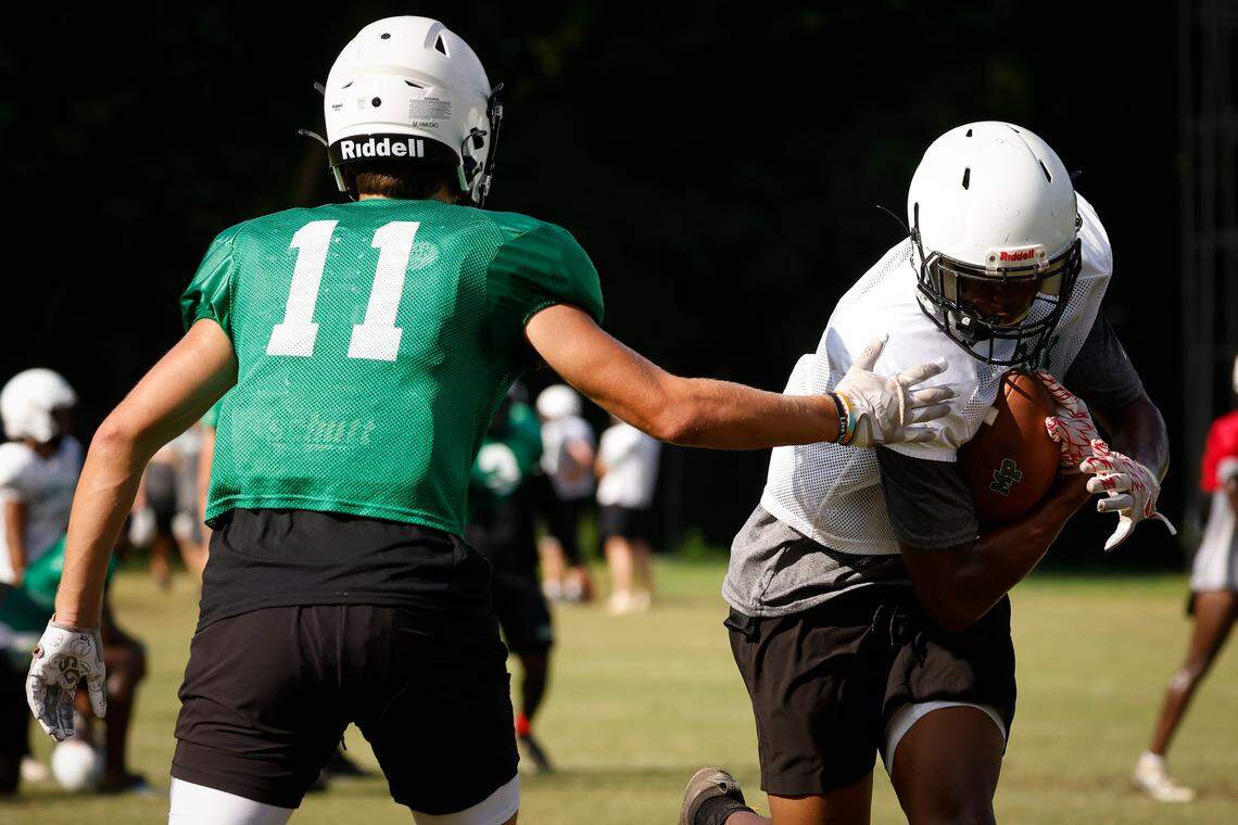 Myers Park wide receivers Max Amedio, left, and Rodney Dunham run drills during practice at Myers Park High School in Charlotte, N.C., Monday, Aug. 8, 2022.