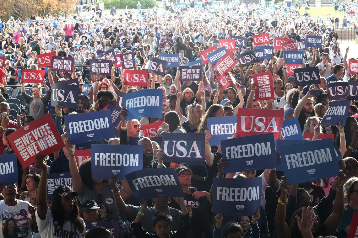 Vice President Kamala Harris’ supporters hold up signs at PNC Music Pavilion on Saturday, November 2, 2024.