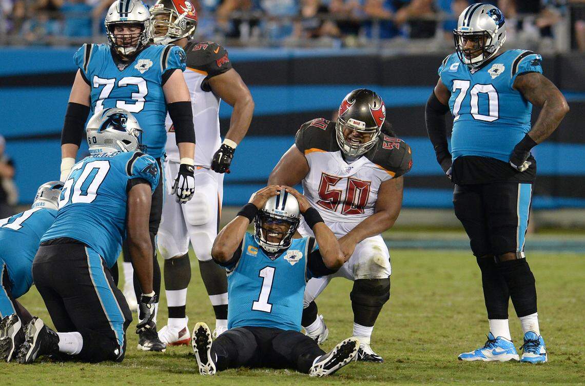 Carolina Panthers quarterback Cam Newton holds onto the top of his helmet after being sacked by Tampa Bay Buccaneers linebacker Shaquil Barrett during third quarter action at Bank of America Stadium on Thursday, September 12, 2019.