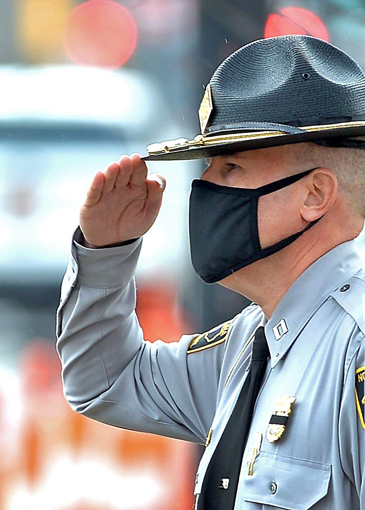 A North Carolina Highway patrolman salutes in Charlotte, NC on Wednesday, December 29, 2021.