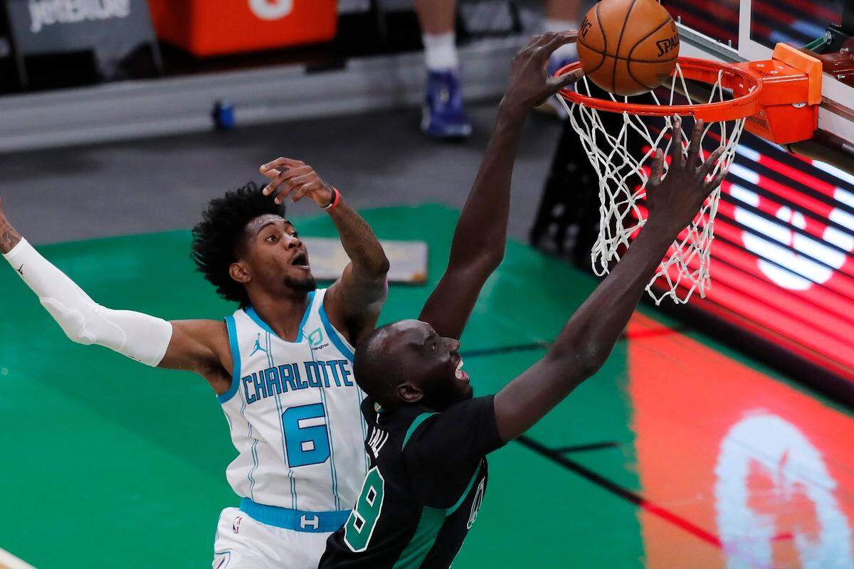 Boston Celtics’ Tacko Fall (99) scores against Charlotte Hornets’ Jalen McDaniels (6) during the second half of an NBA basketball game, Sunday, April 4, 2021, in Boston. (AP Photo/Michael Dwyer)