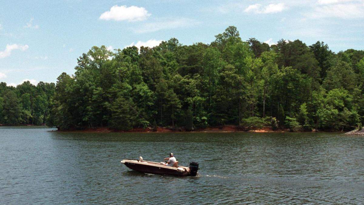 A boater on Lake Wylie cruises by the shore of Copperhead Island at McDowell Park on in June 2001. The island is an undeveloped section operated by the City of Charlotte and McDowell Nature Preserve Park.