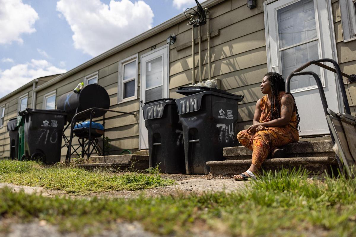 Lachelle Cherry poses for a portrait on her porch at Brookhill Village Apartments in Charlotte, N.C., on Monday, July 31, 2023.