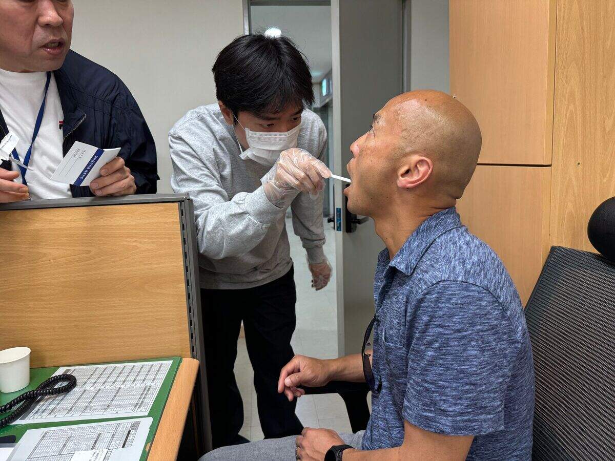 A member of the Seodaemun District police station in Seoul collects a DNA sample from Théoden Janes during the “active search” for his birth family.