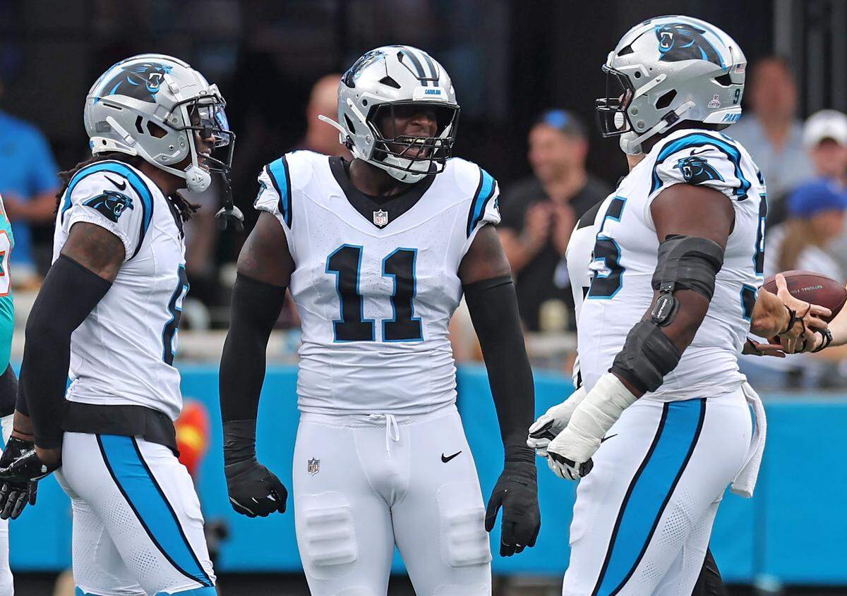 Carolina Panthers cornerback Jaycee Horn, left, and linebacker Nic Scourton, center, congratulate defensive end Derrick Brown, right, following his sack of Miami Dolphins quarterback Tua Tagovailoa on Oct. 5, 2025, at Bank of America Stadium. The Panthers defeated the Dolphins 27-24.