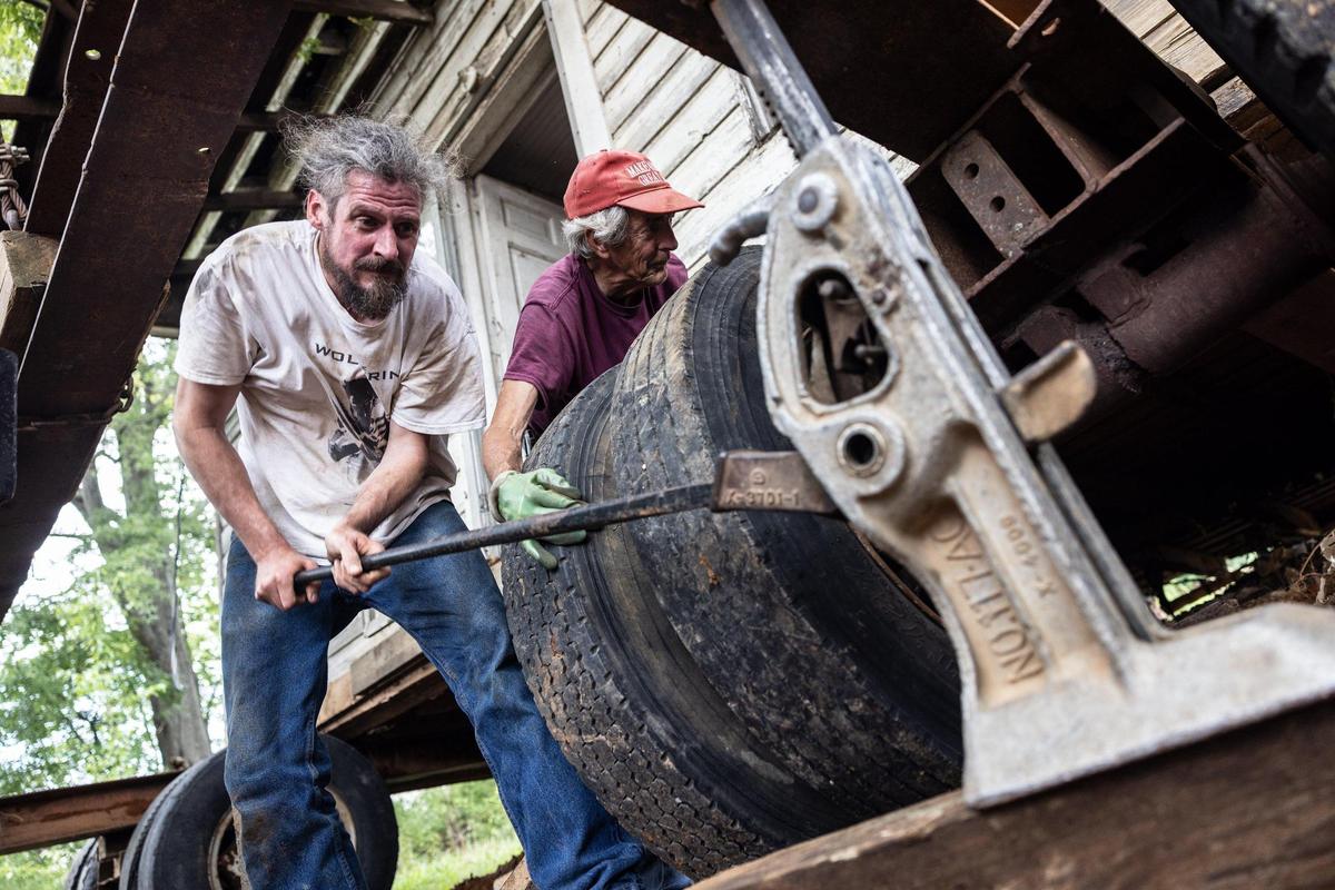 Oliver Wright, left, and his dad, W.C., put wheels under the Alexander Farm Tenant House before moving it across a 55-acre farm in Cornelius. A developer is planning to start work soon on a mixed-use project there.