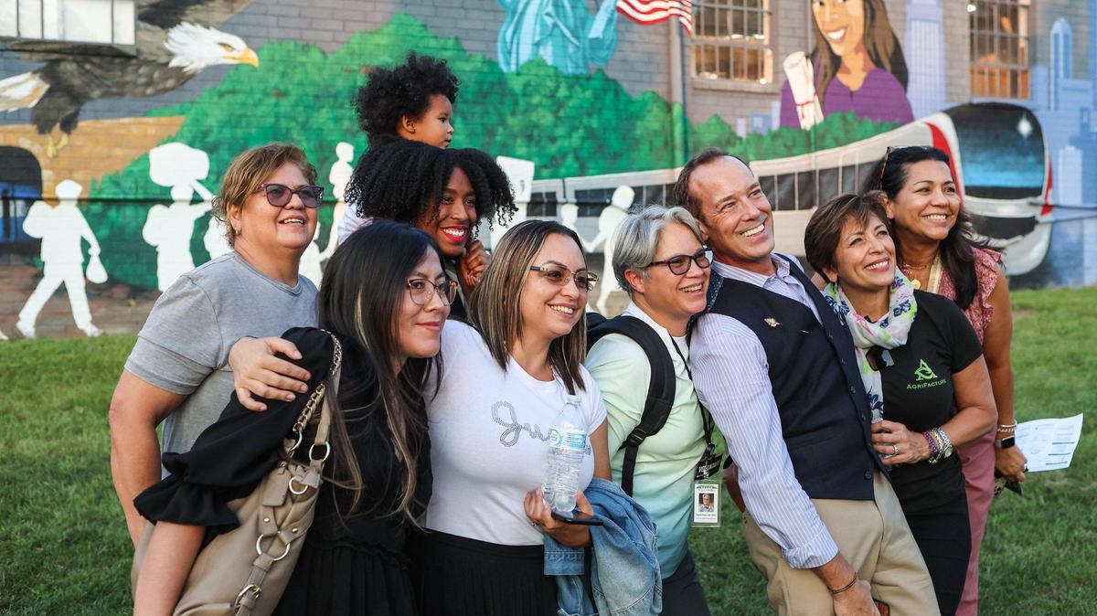 People pose with mural artist, Randall Kane, third from right, during Camino’s Celebra Arte & Cultura, an event celebrating the beginning of Hispanic Heritage Month, on Thursday, September 15, 2022 in Charlotte, NC.