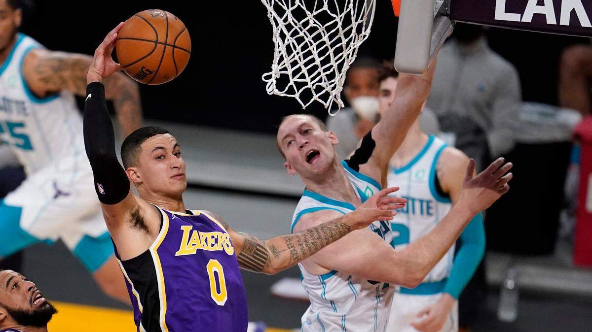Los Angeles Lakers forward Kyle Kuzma (0) grabs a rebound in front of Charlotte Hornets center Cody Zeller during the first half of an NBA basketball game Thursday, March 18, 2021, in Los Angeles. (AP Photo/Marcio Jose Sanchez)