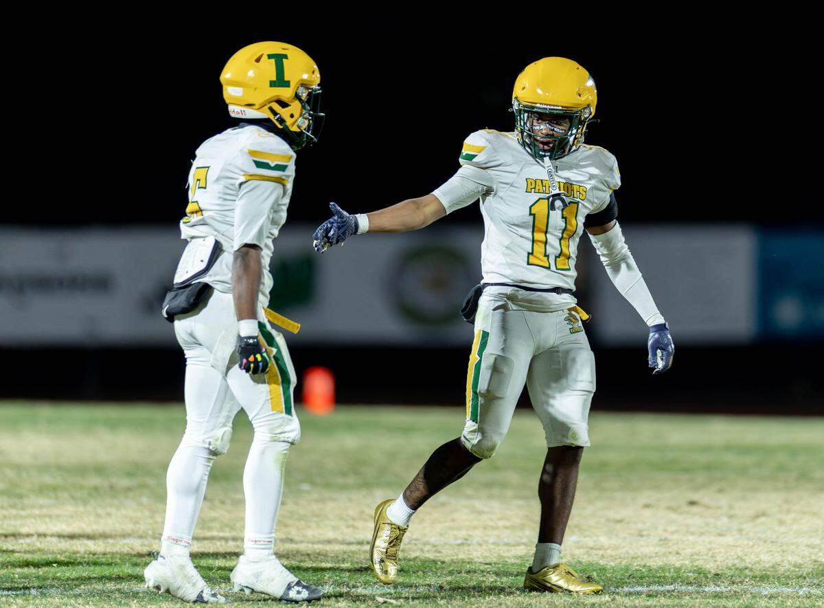 Independence defensive back Nick Reddish (11) and Eli Sellars (5) celebrate a turn over on downs. Weddington would host Independence in the NCHSAA quarterfinal playoff game Friday, November, 28 2025.