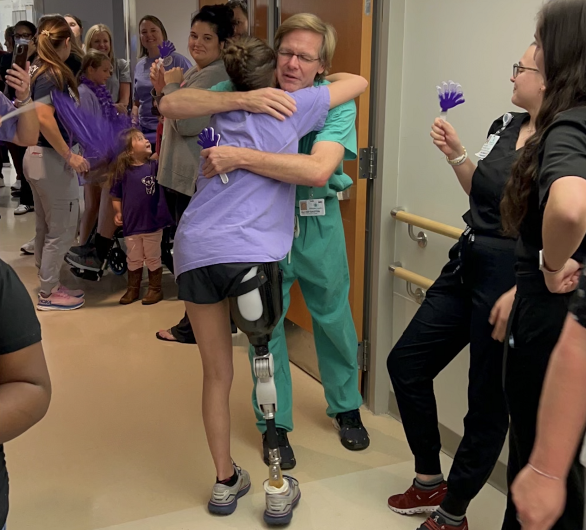 Dr. Glenn Gaston shares a hug with Lulu Gribbin during a test run on her new prosthetic leg last year.