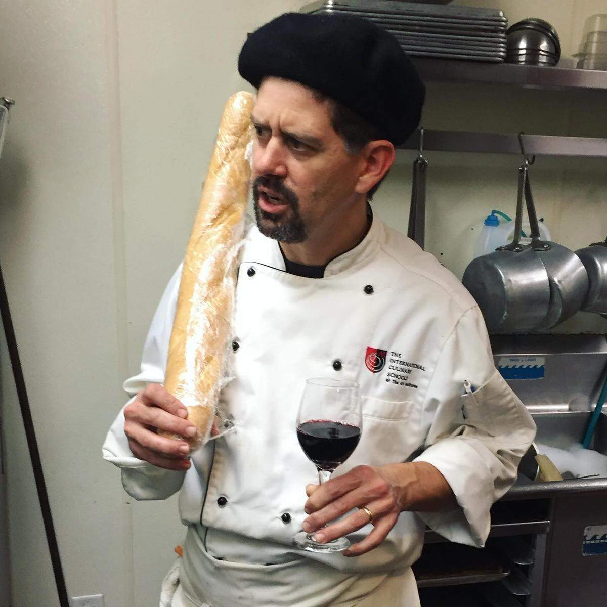 Santé chef/co-owner Adam Reed with a French baguette and a glass of red wine.