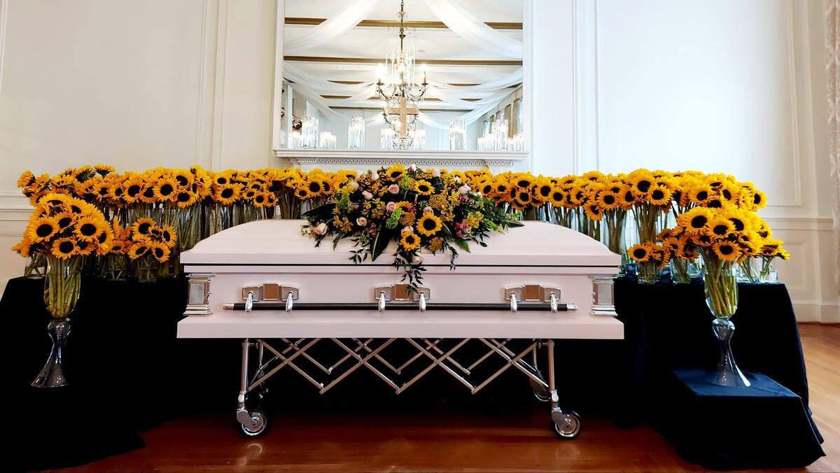 Morgan Wetherbee’s coffin rests among a sea of sunflowers at her memorial service on Monday at Hotel Concord.
