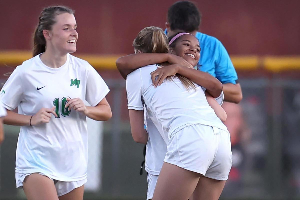Myers Park’s Amaya Falzarano, right, smiles as she is hugged by a teammate after scoring a goal against South Meck on Tuesday, May 6, 2025.