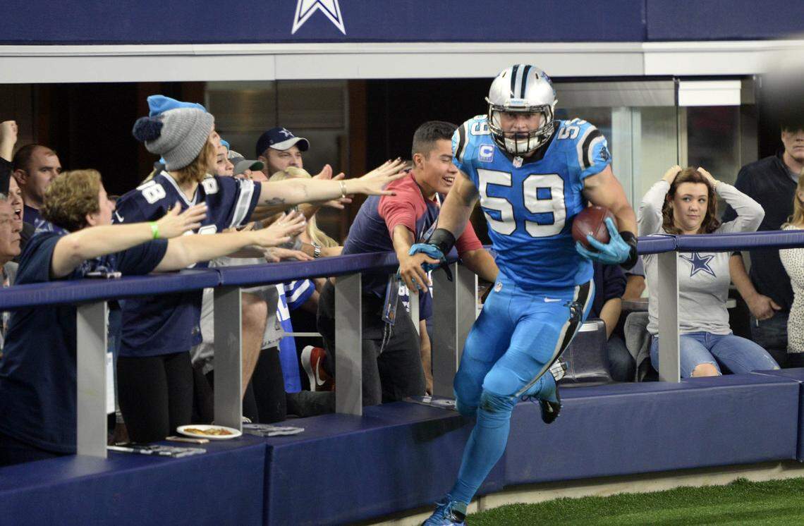 Dallas Cowboys fans react to the Carolina Panthers’ Luke Kuechly (59) scoring a touchdown after intercepting a Tony Romo (9) pass. Kuechly intercepted Romo on consecutive plays in Carolina’s 33-14 win.