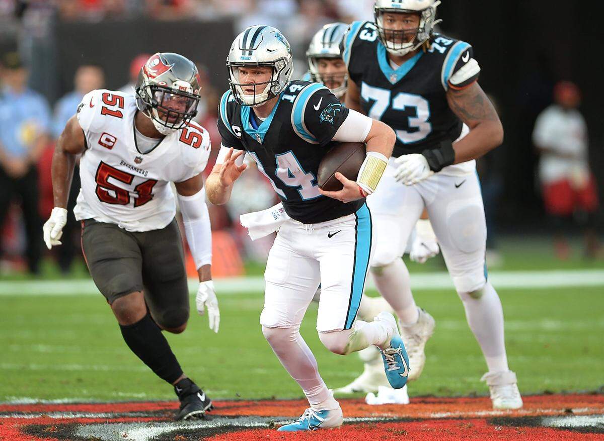 Carolina Panthers quarterback Sam Darnold runs out of the pocket for yardage as Tampa Bay Buccaneers linebacker Kevin Minter, left, chases during first quarter action at Raymond James Stadium in Tampa, Fl. on Sunday, January 9, 2022.