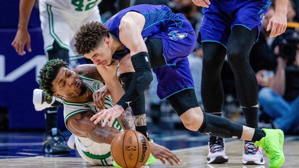 Boston Celtics guard Marcus Smart (36) and Charlotte Hornets guard LaMelo Ball (1) battle for a loose ball during the second half of an NBA basketball game on Saturday, Jan. 14, 2023, in Charlotte, N.C. (AP Photo/Scott Kinser)