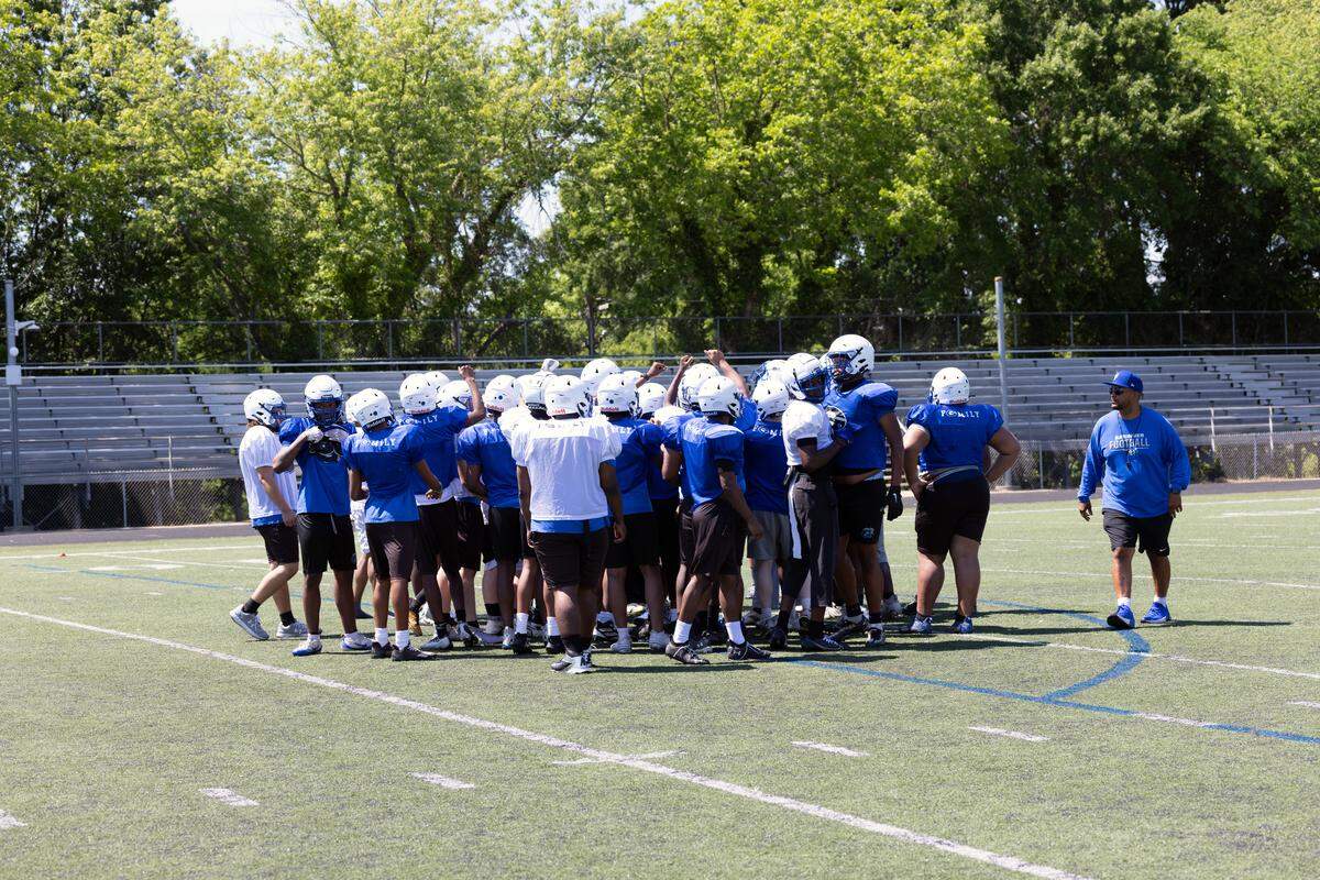 Garinger High School football players huddle during a spring workout. With 14 starters returning for the 2026 season, head coach Jupiter Wilson and his Wildcats are dreaming big about the program’s trajectory. 